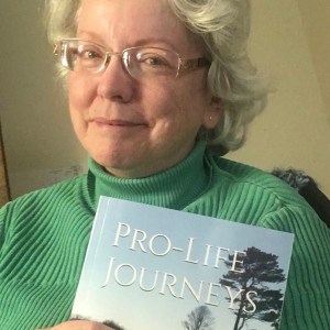 Author Ellen Kolb displaying a copy of her book entitled "Pro-Life Journeys"